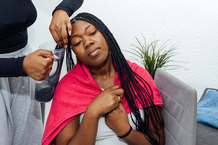 African-american woman getting box braids styled at home