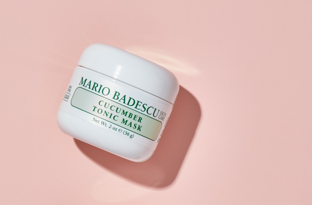 A white jar labeled "Mario Badescu Cucumber Tonic Mask" on a pink background.